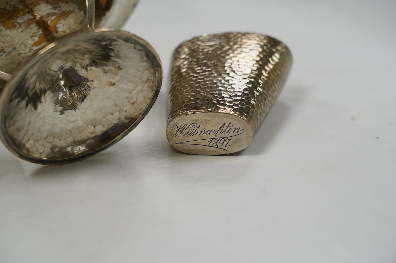 A George V Arts & Crafts planished silver bowl, on tripod supports and circular foot, Walker & Hall, Sheffield, 1912, diameter 15.7cm and a German planished vase inscribed 'Weihnachten 1897'. Condition - fair